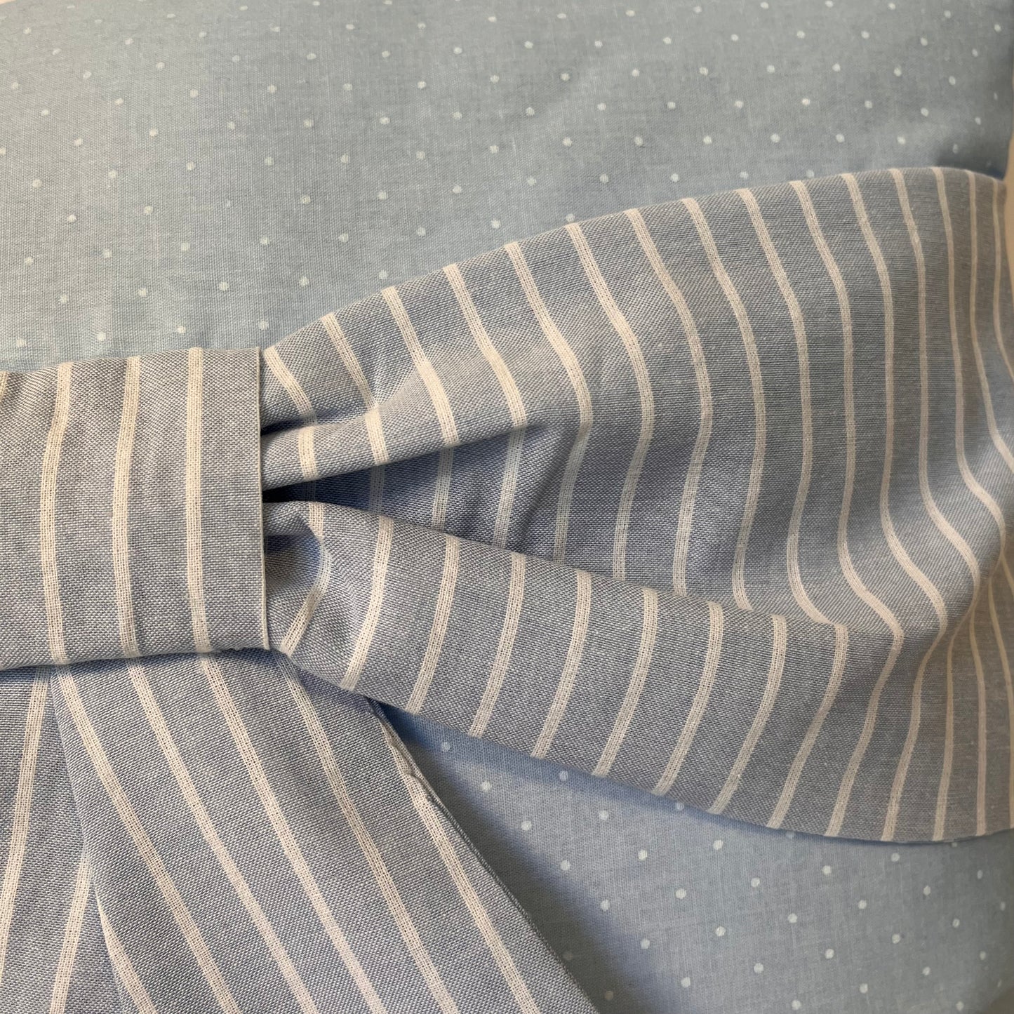 Light blue fabric with white polka dots and a bow made of light blue and white striped fabric
