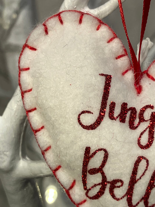 Close-up of the red glitter Jingle Bells text on a white felt heart ornament.