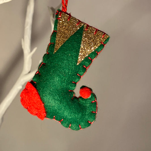 Handmade green felt elf boot ornament with red heel and toe, gold glitter cuff, and red stitching.