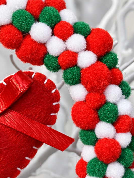 Close-up of the colorful red, white, and green pom-poms on a wreath.