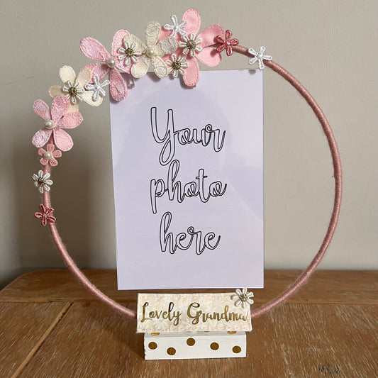 Pink yarn-wrapped hoop photo frame with fabric flowers and a 'Lovely Grandma' plaque.