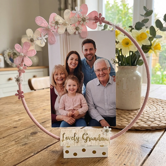 A pink floral hoop photo frame with a family photo and a Lovely Grandma sign.