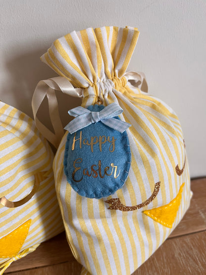 Yellow and white striped Easter gift bag with a blue felt egg tag that says Happy Easter.