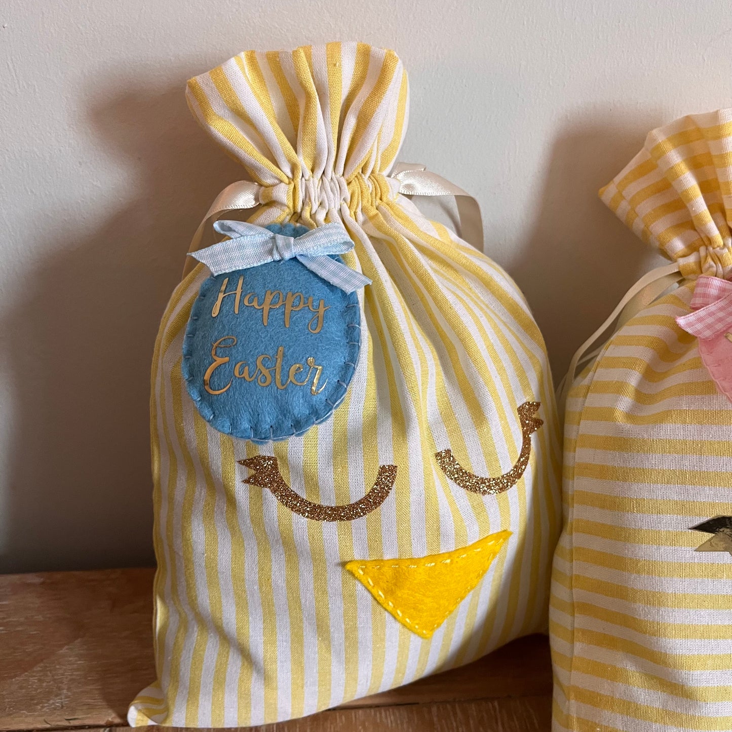 Yellow and white striped Easter chick gift bag with a blue Happy Easter tag and glittery eyes.