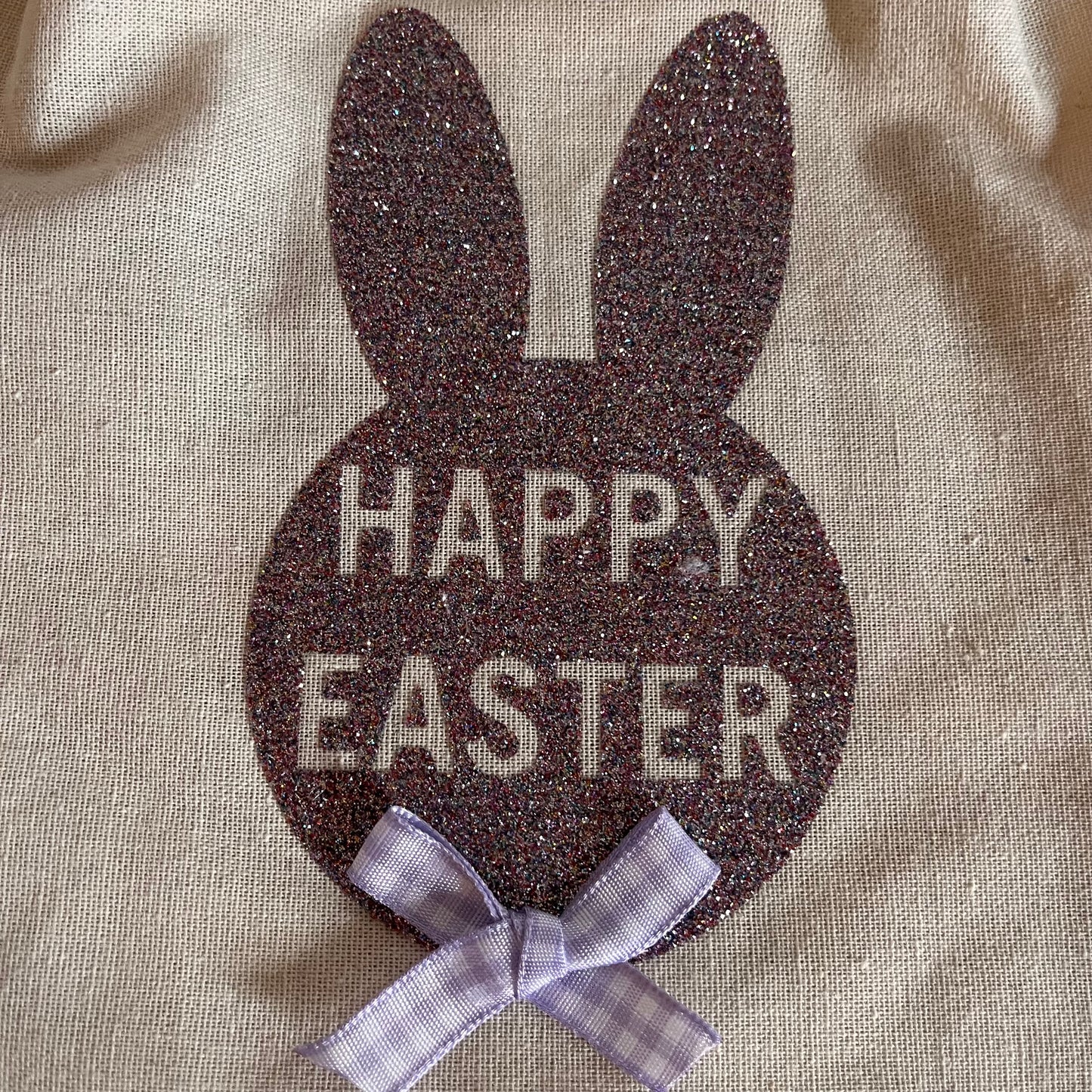 Glittery purple bunny shape with Happy Easter text and a small checkered purple bow.