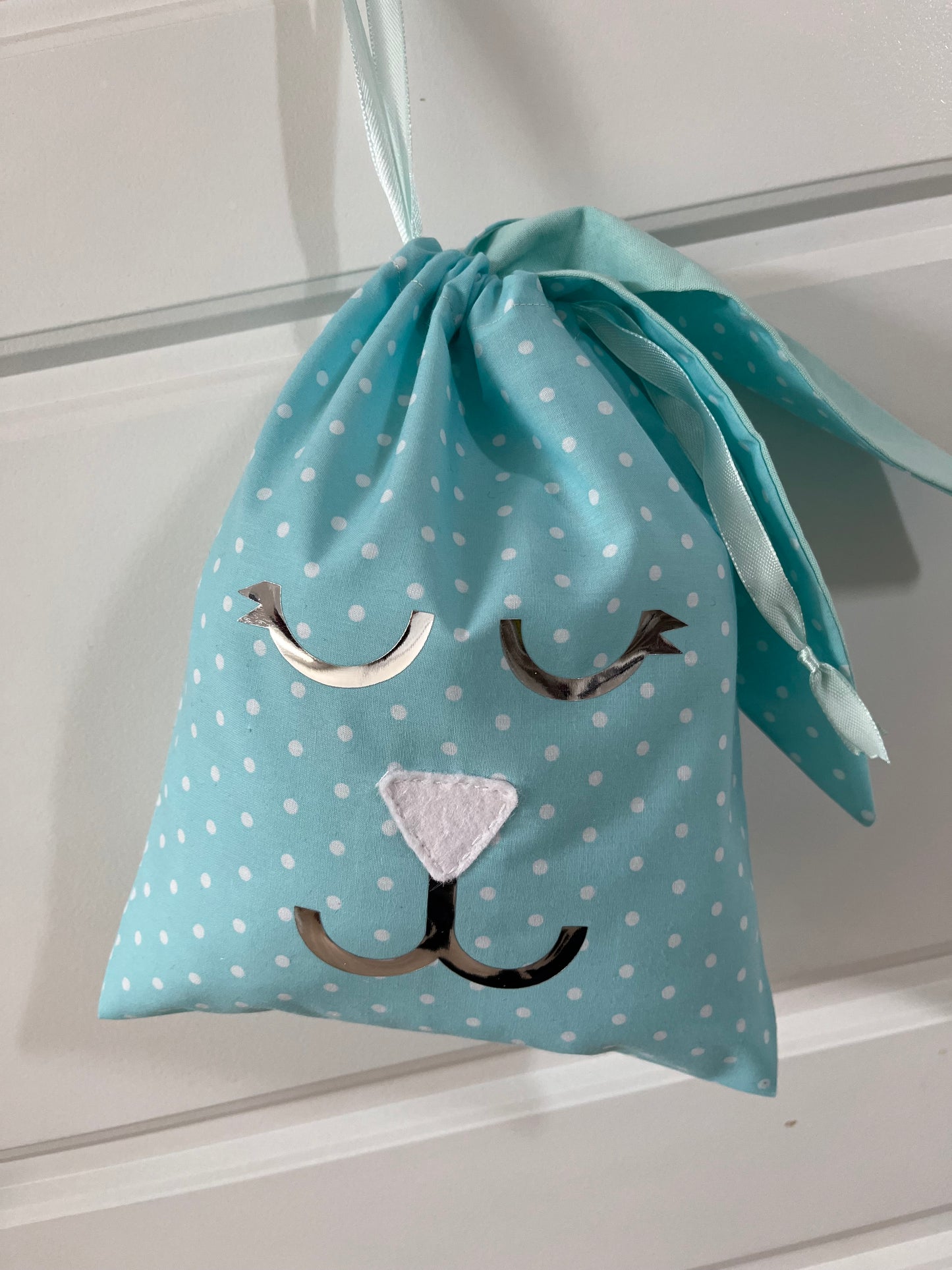 Blue polka dot drawstring bag with a bunny face design