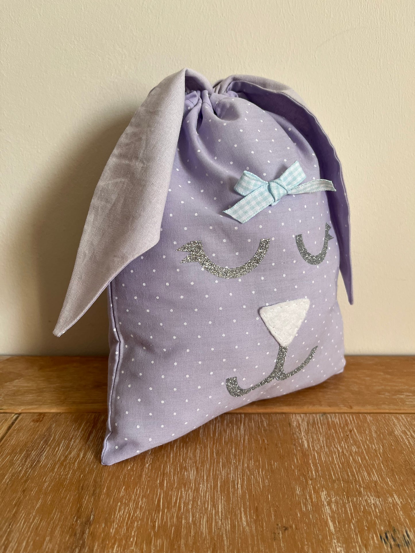 Purple polka dot bunny ear drawstring bag with glitter face and blue gingham bow