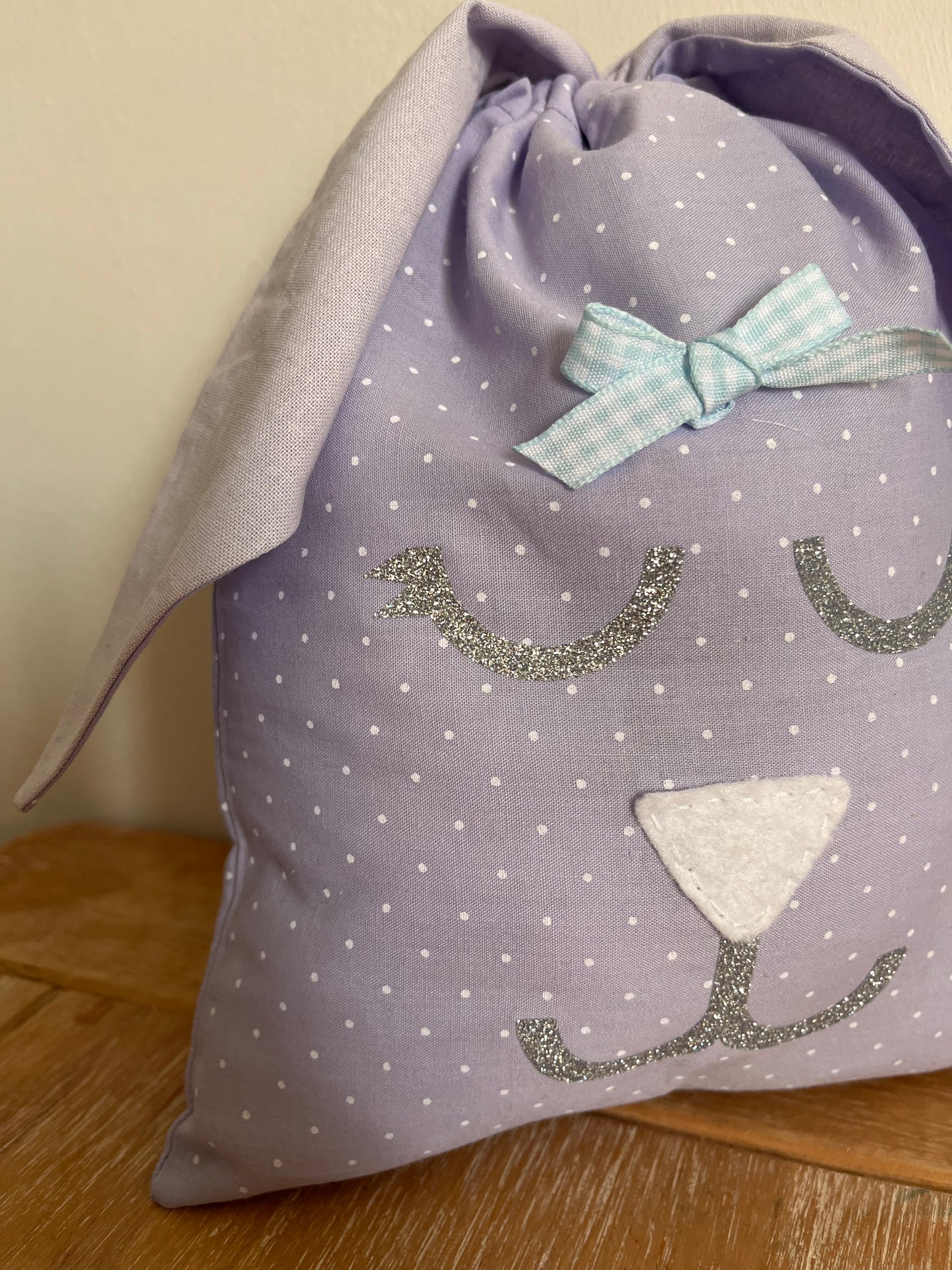 Purple polka dot bunny bag with glittery eyes, white nose, and blue gingham bow