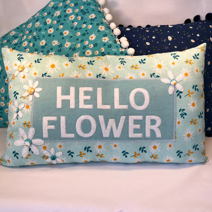 Hello Flower pillow with daisy pattern and pom-pom trim
