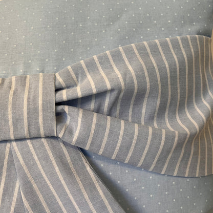 Light blue fabric with white polka dots and a bow made of light blue and white striped fabric