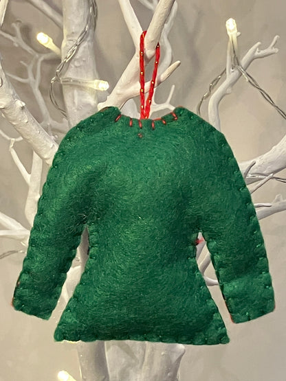 Back of green felt elf shirt ornament with red hanging string on a white branch.