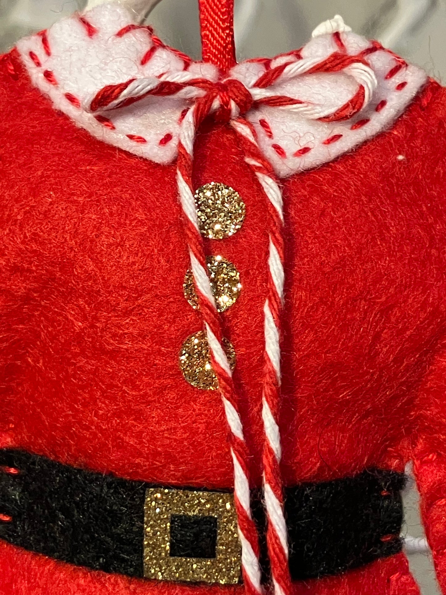Close-up of the collar and buttons of a red Santa's jacket Christmas decoration.