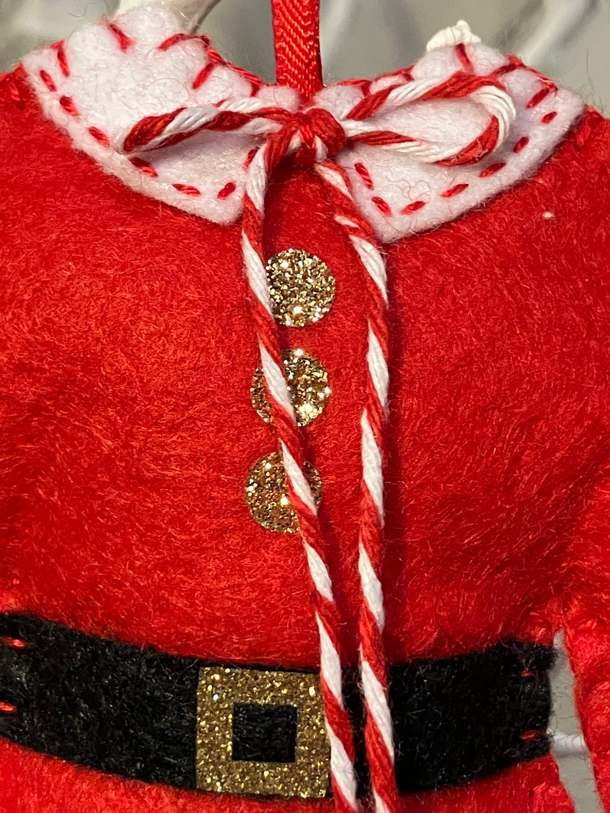 Close-up of the collar and buttons of a red Santa's jacket Christmas decoration.