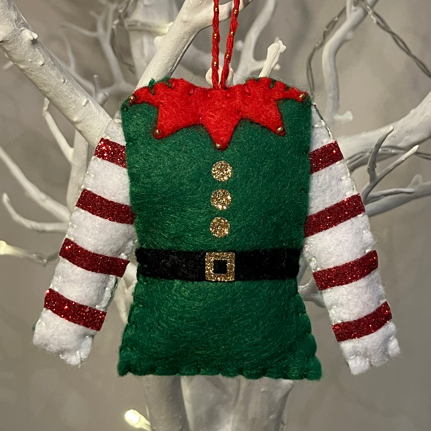 Green elf felt Christmas ornament with red collar and candy cane striped sleeves.