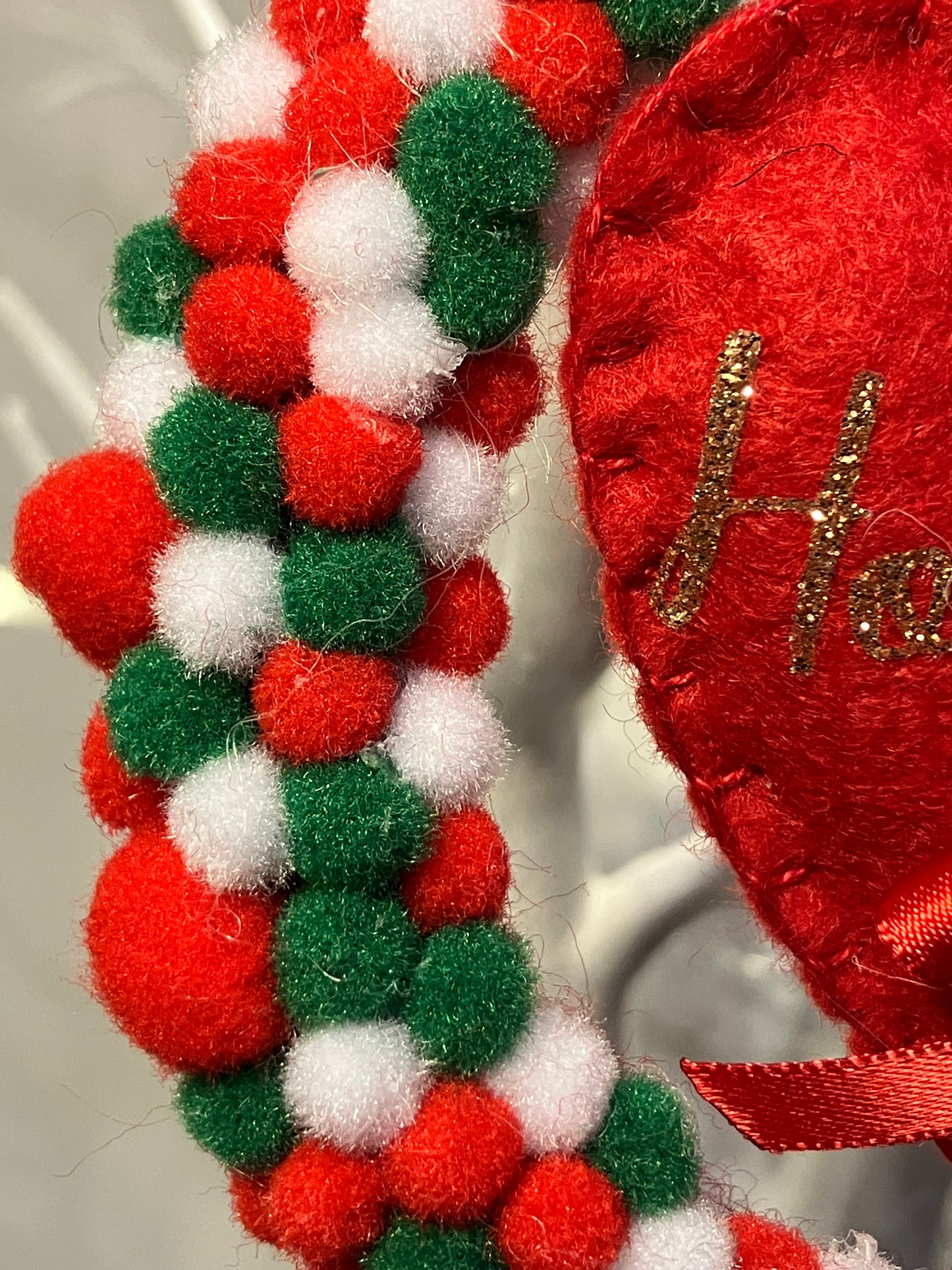 Close-up of a red, white, and green pom-pom wreath.
