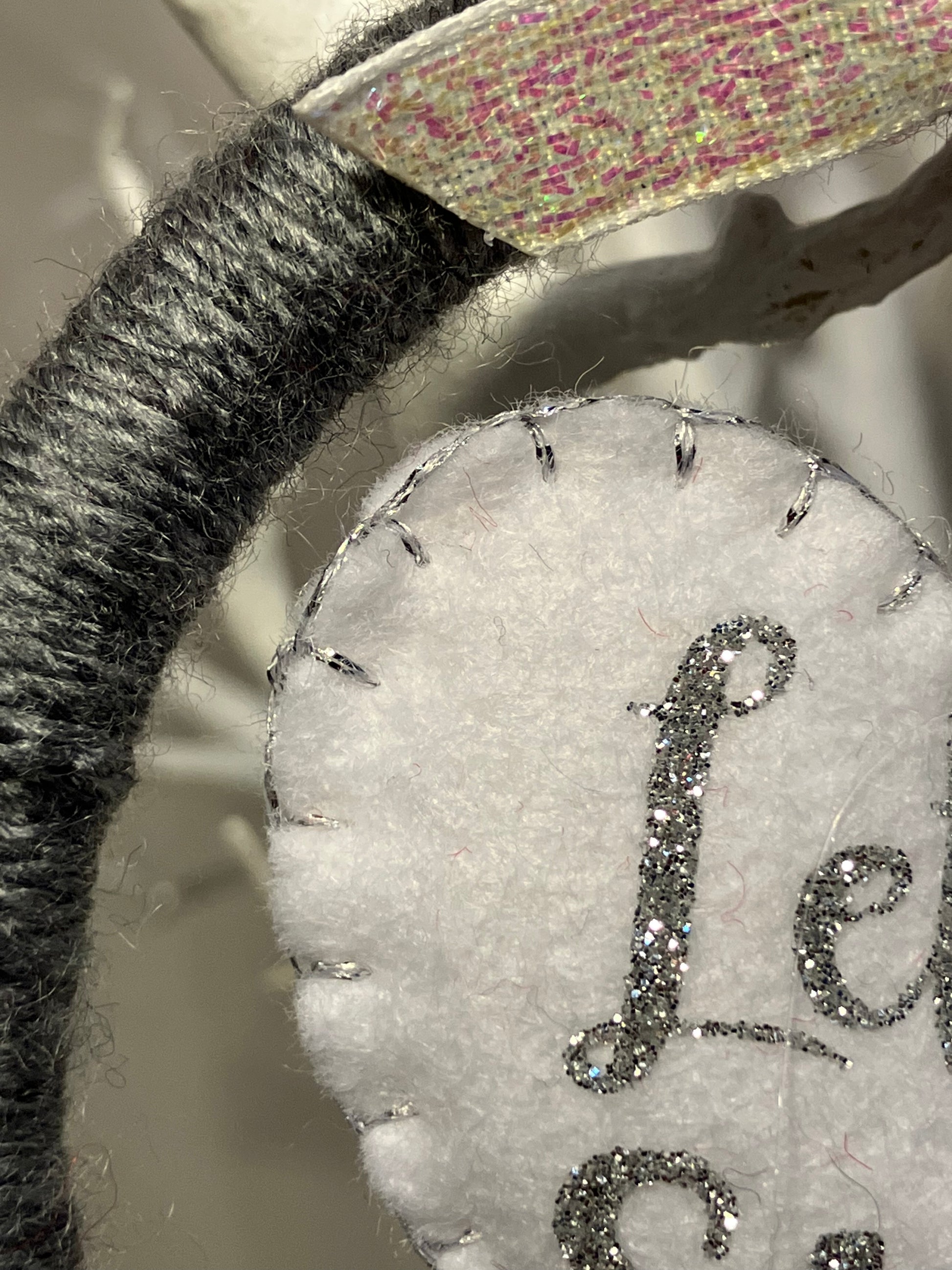 Close-up of the gray yarn wreath and the white felt heart ornament.
