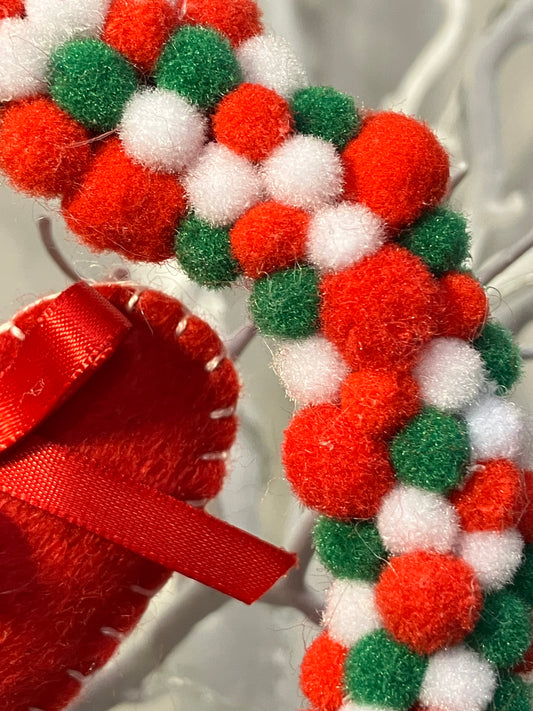 Close-up of the colorful red, white, and green pom-poms on a wreath.