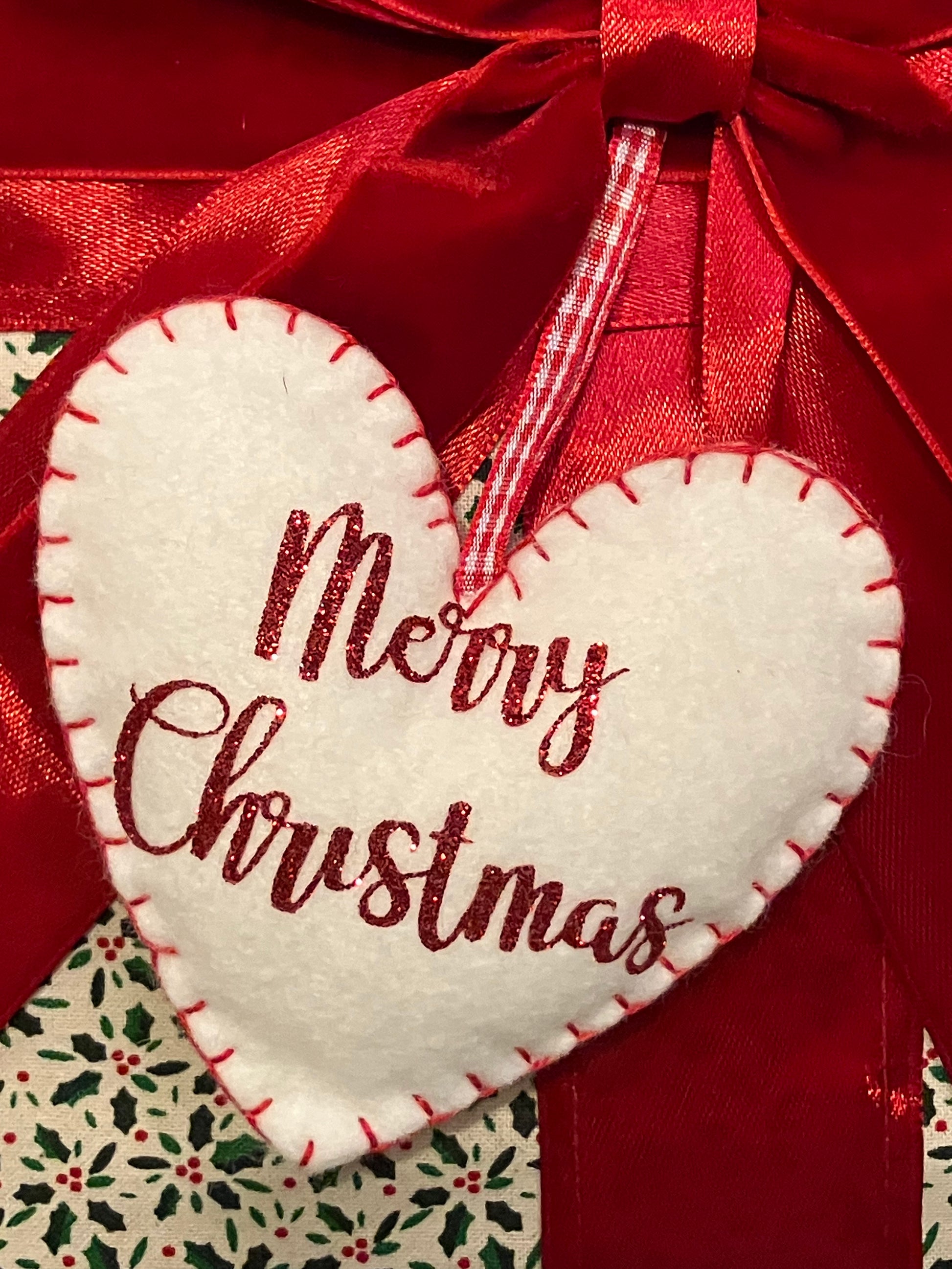 Detailed view of the 'Merry Christmas' heart-shaped tag on a festive cushion.