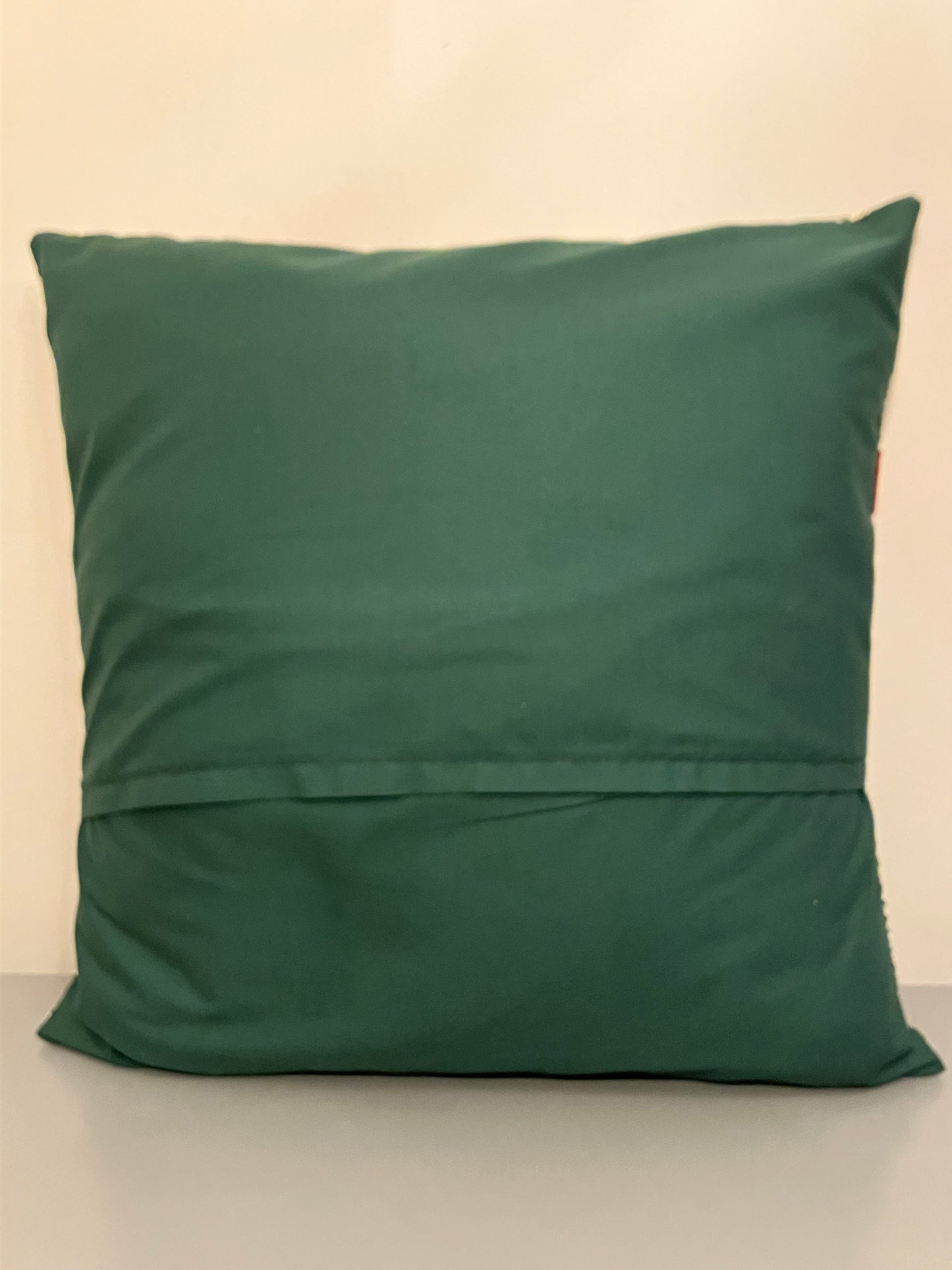 The plain green back of a festive cushion.