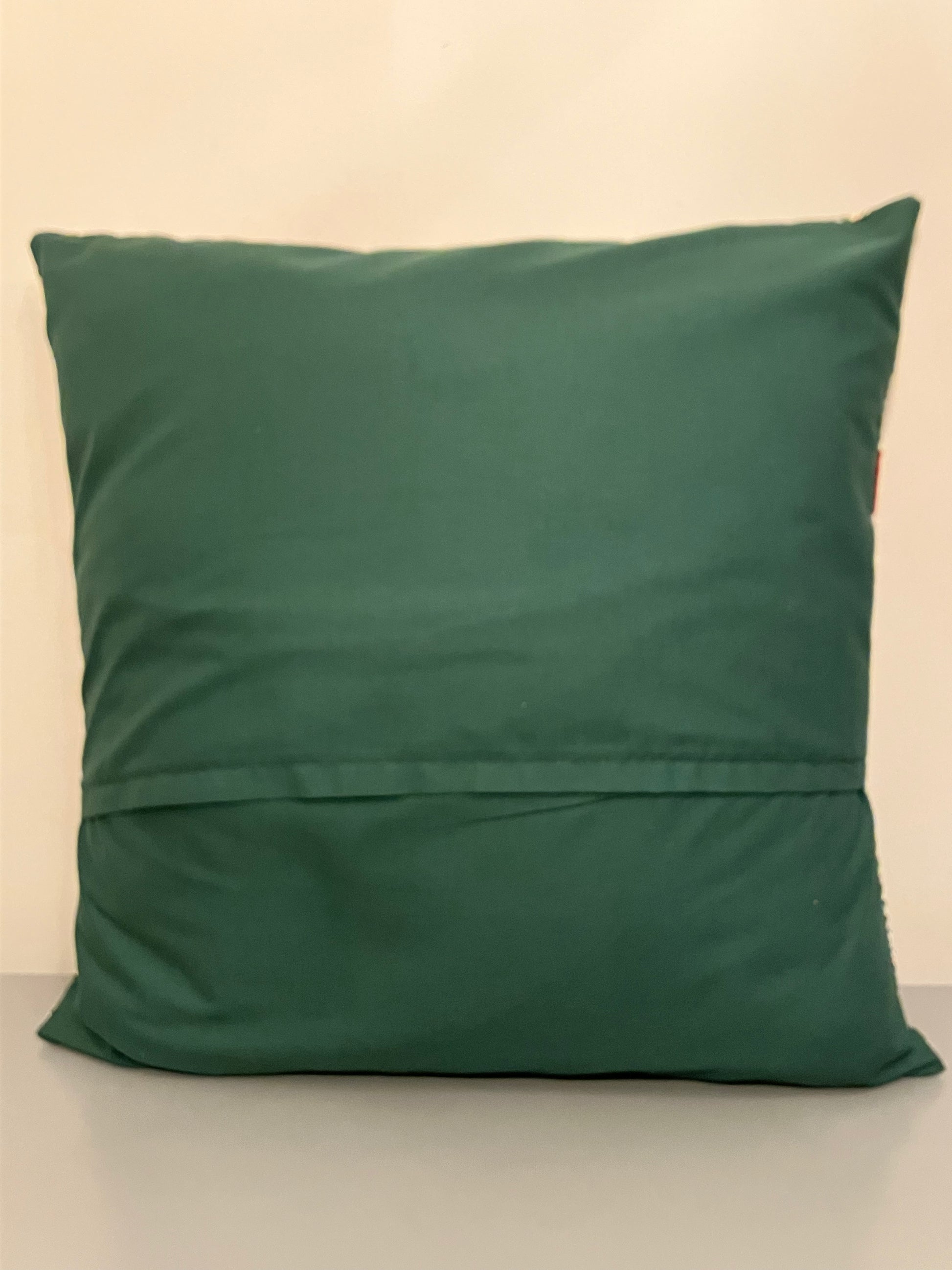 The plain green back of a festive cushion.
