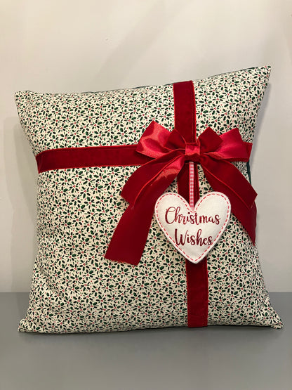 Christmas cushion with a festive pattern, red ribbon, and a 'Christmas Wishes' heart.