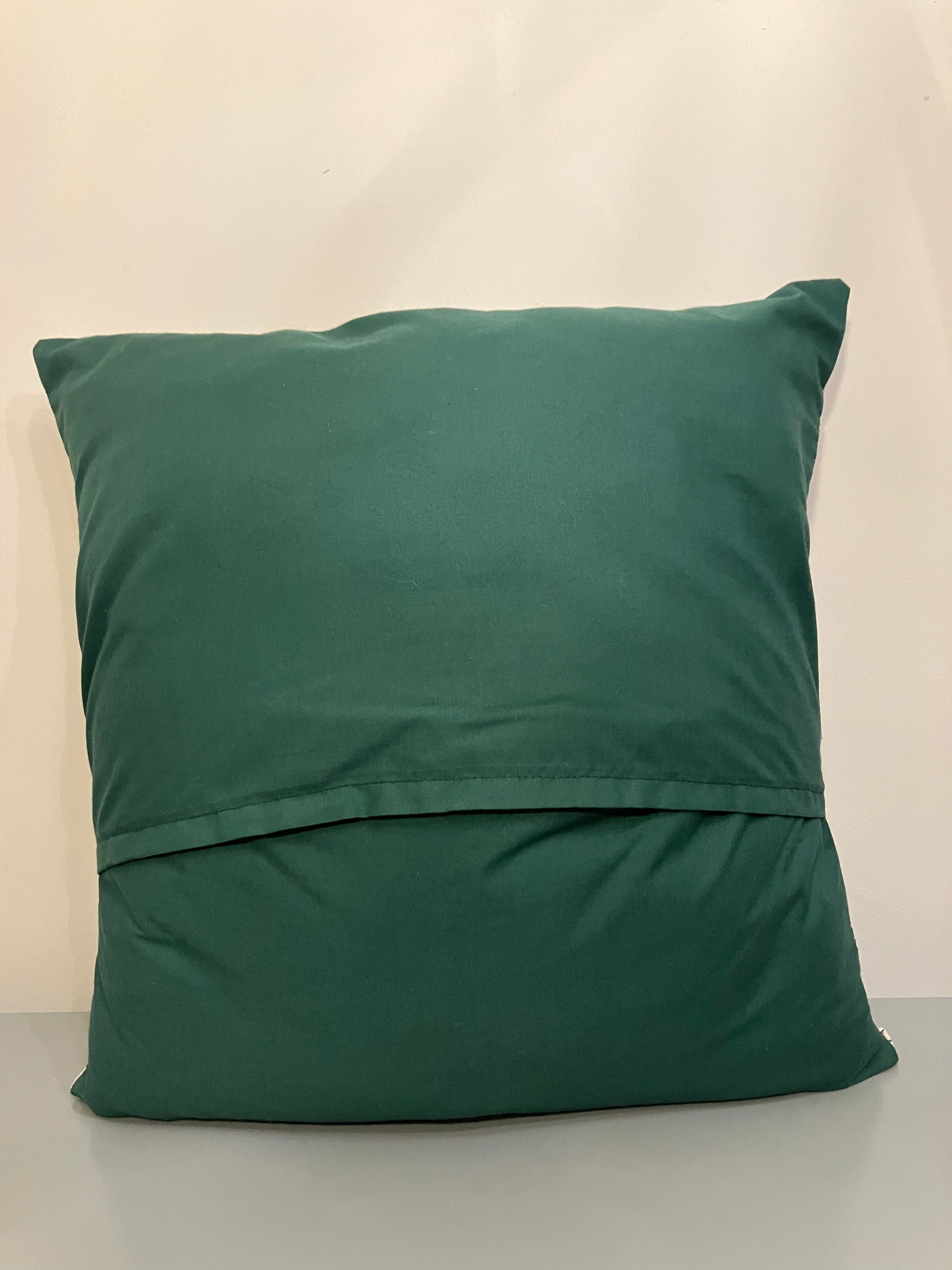 Back of the Christmas cushion, showing a plain dark green fabric.