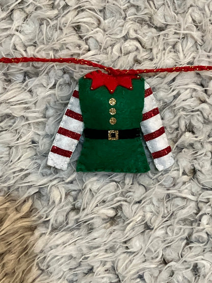 A closeup of a single green elf outfit with red and white striped sleeves.