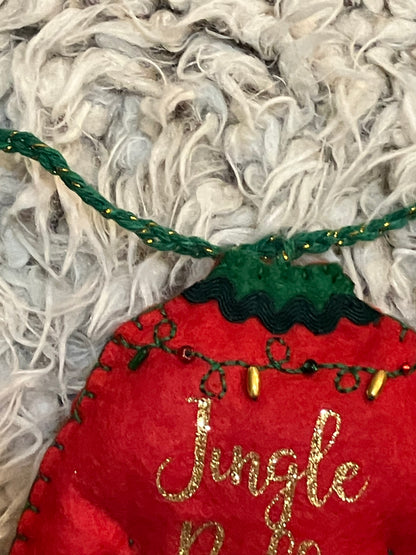 Close-up of the green string and top of the red felt Jingle Bells Christmas sweater ornament.