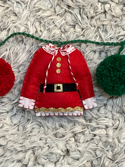 A miniature red Mrs. Claus jacket with a white collar and gold trim.