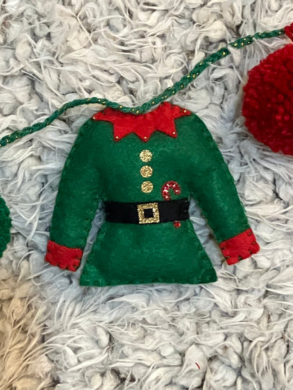 A miniature green elf jacket with a red collar and a small candy cane detail.