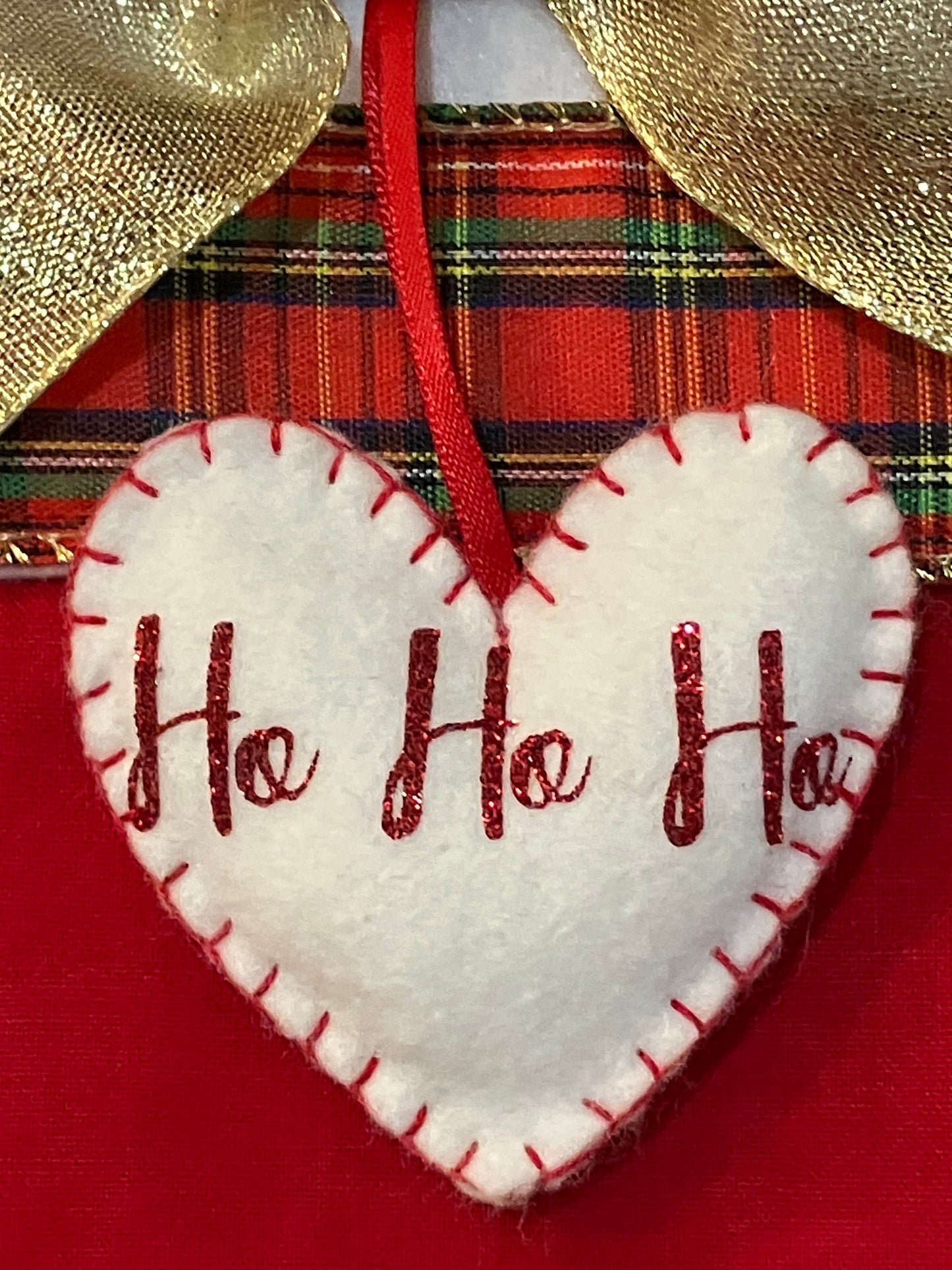 Close-up of the "Ho Ho Ho" heart ornament on the Christmas stocking.