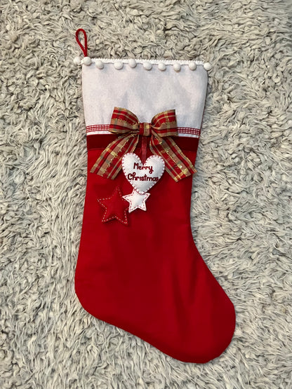 A red Christmas stocking with a plaid bow, felt heart, and two felt stars.