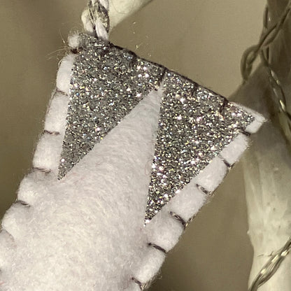 White felt Christmas stocking with silver glitter triangles and black stitching.