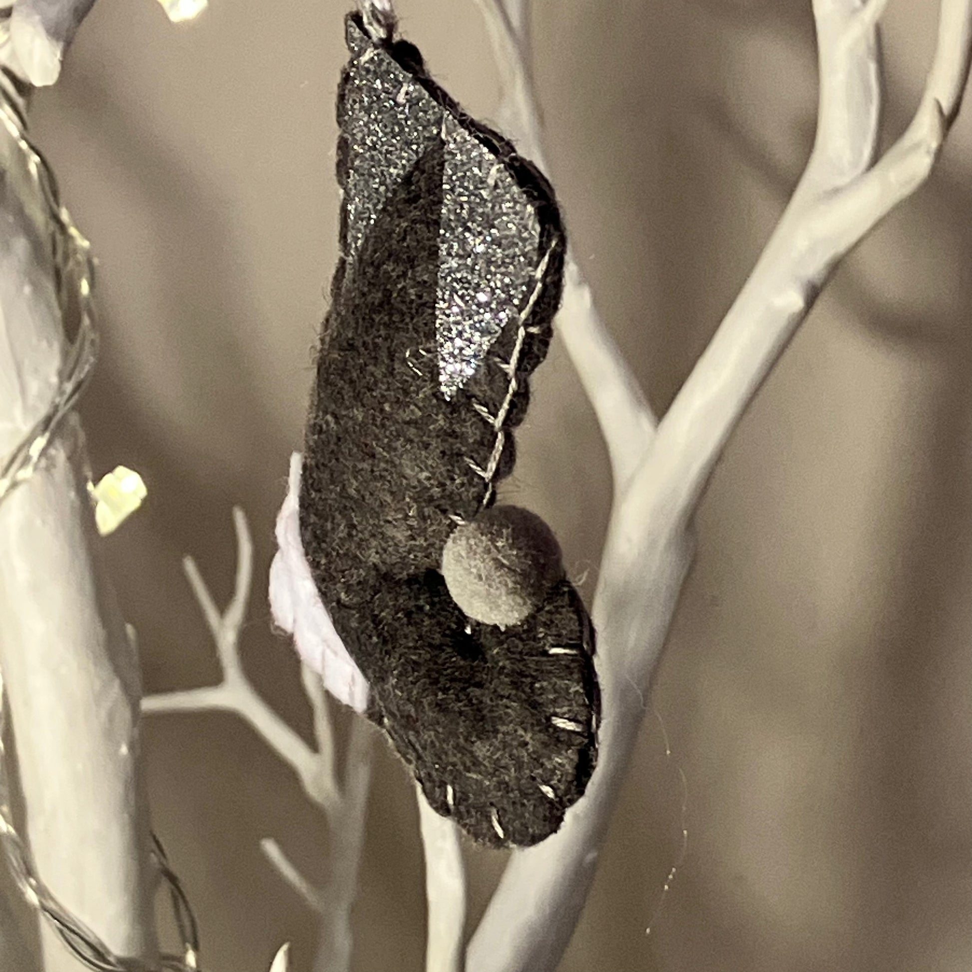 Handmade dark gray felt bat ornament with glitter wings and a small pom-pom nose.