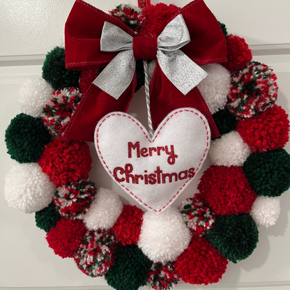 A festive red, green, and white pom-pom wreath with a "Merry Christmas" heart.