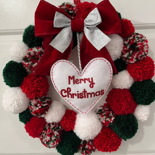 A festive red, green, and white pom-pom wreath with a "Merry Christmas" heart.