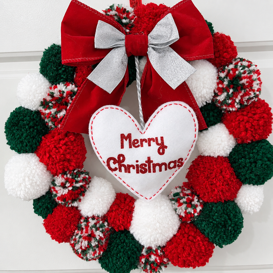 A festive red, green, and white pom-pom wreath with a "Merry Christmas" heart.