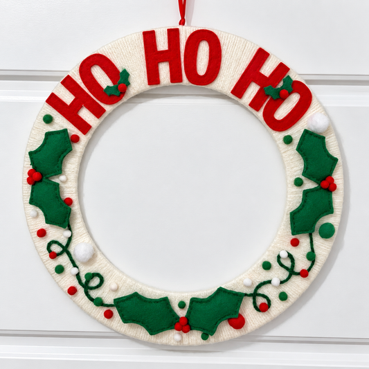 Handmade Christmas wreath with "HO HO HO" in red letters and felt holly leaves.