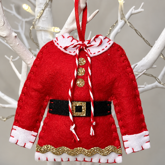 A close-up of a festive Santa's jacket hanging on a white branch for Christmas decoration.