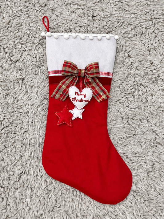 Red and white Christmas stocking with a plaid bow and a heart that says "Merry Christmas".