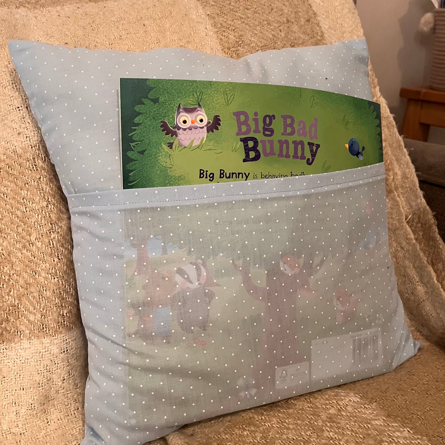 Light blue polka dot pillow with a book titled Big Bad Bunny in its front pocket.
