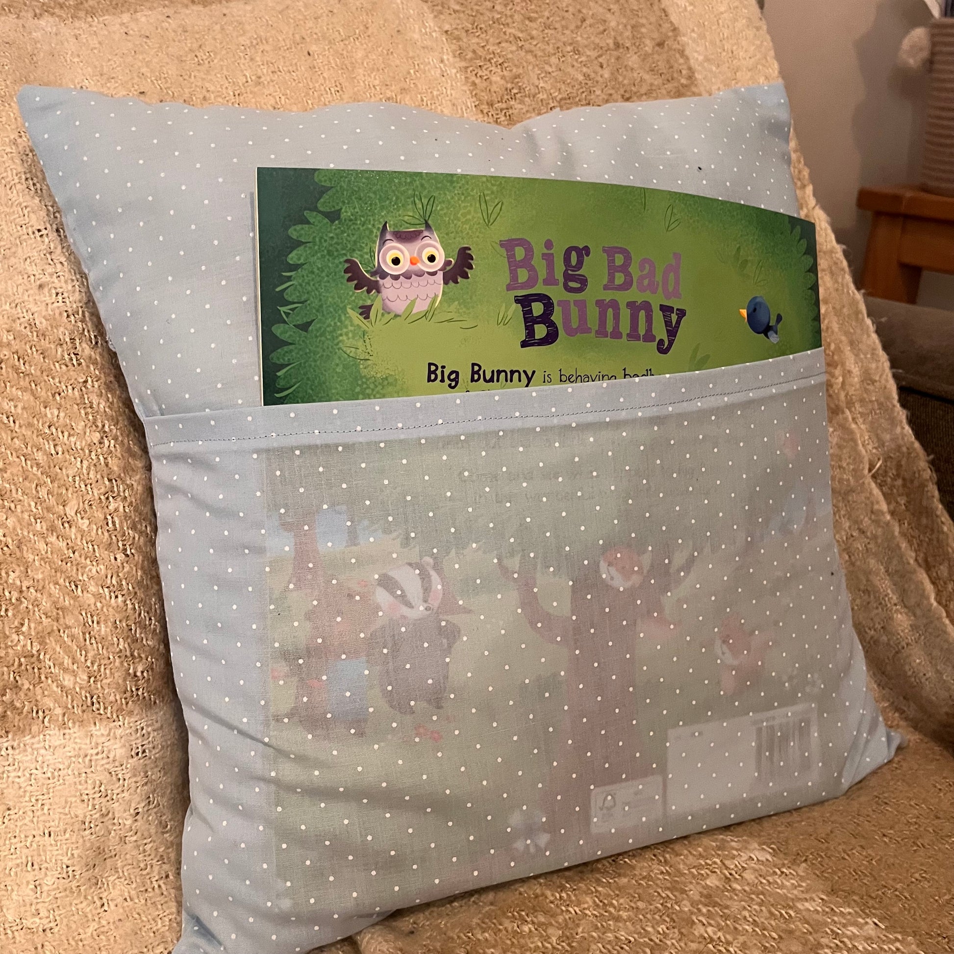 Light blue polka dot pillow with a book titled Big Bad Bunny in its front pocket.