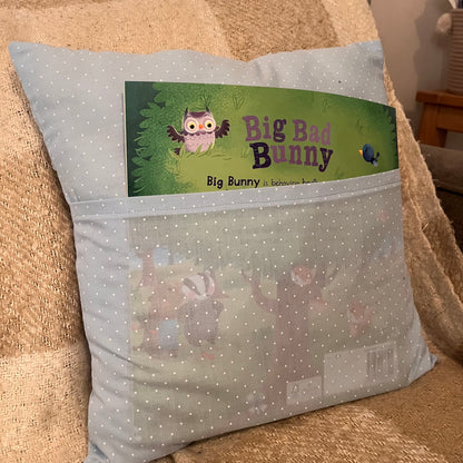 Light blue polka dot pillow with a book titled Big Bad Bunny in its front pocket.
